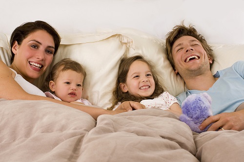 bigstock-happy-young-family-laying-in-b-15702011.jpg